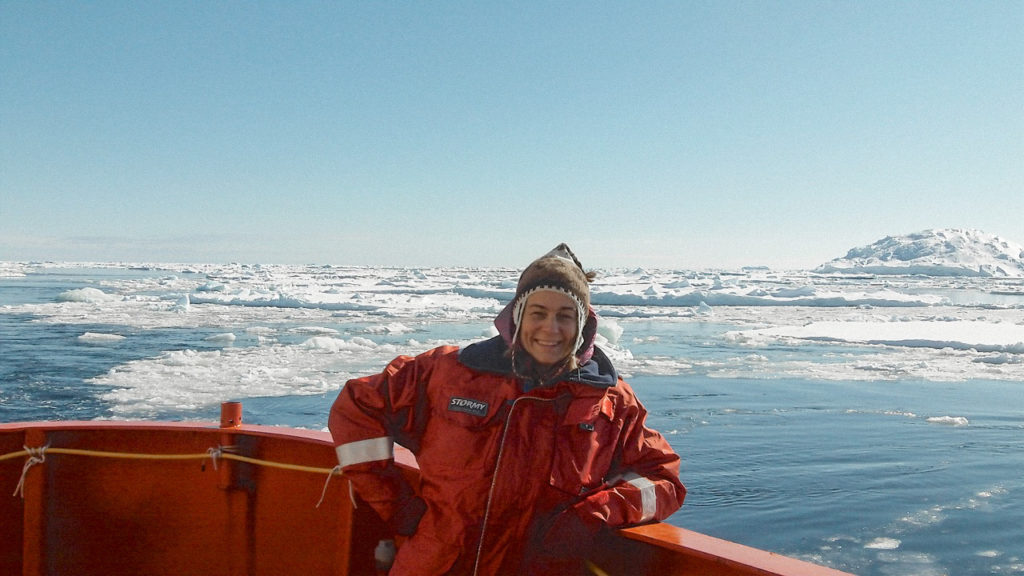 A woman (Leanne Armand) stood at the prow of a ship in front of some iceburgs