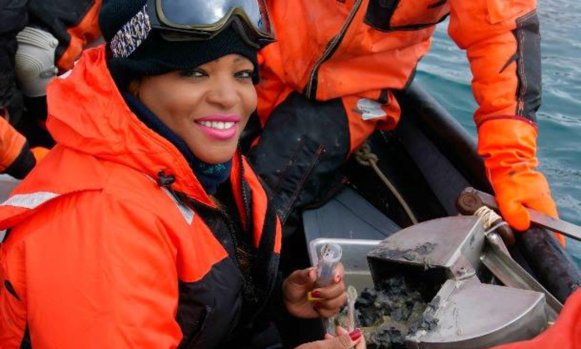 A woman sat on a boat sampling mud