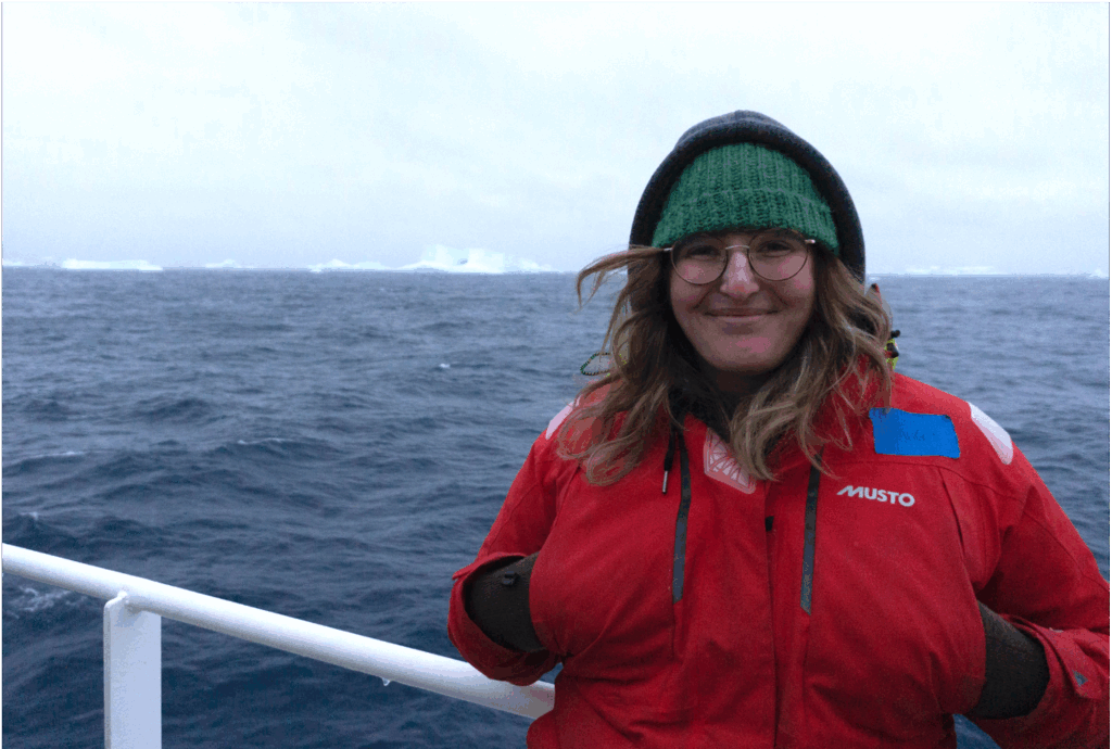 Margot leans against the reeling of a ship. This picture was taken in 2023 on RV Roger Revelle, during US GEOTRACES research cruise GP17-OCE, to the South Pacific and the Southern Ocean. Margot left from Papeete, French Polynesia and arrived into Punta Arenas, Chile, after 2.5 months of studying trace elements and their isotopes across the frontal regions of the Pacific Southern Ocean sector.