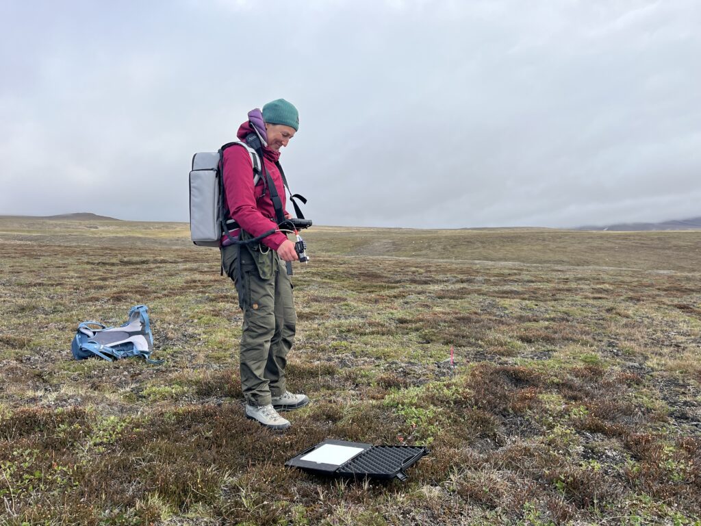 Field work in August 2025. Picture shows how Gabriela is making spectral reflectance measurements of tundra vegetation in Zackenberg to test how spectral variability relates to biodiversity captured from botanical relevees and eDNA. Photo taken by Jakob Assmann.